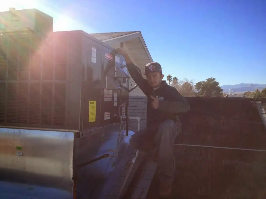 HVAC technician performing AC Tune-Up on a rooftop unit in Oak Hill